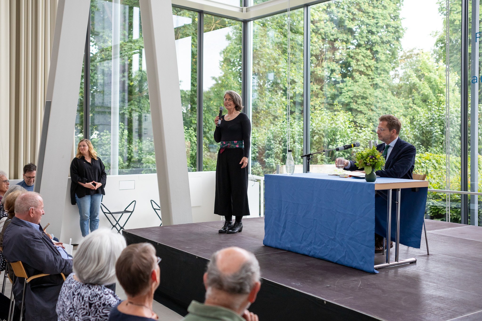 Auf dem Podium steht Dr. Birte Frenssen, daneben sitzt Florian Illies. Foto: André Gschweng.